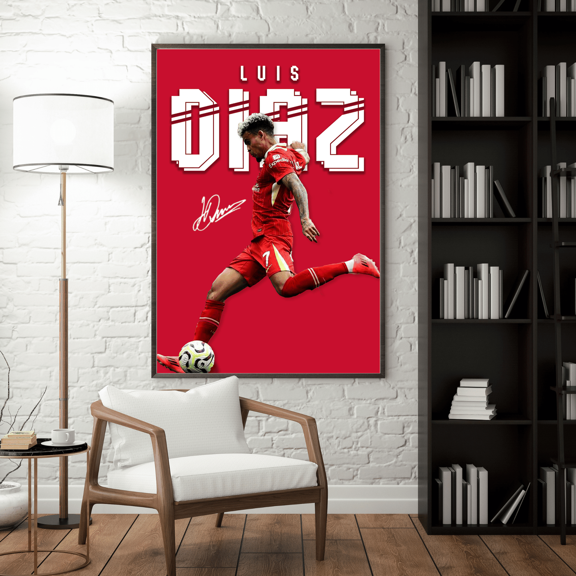 Framed poster of a soccer player in red uniform on a red background, leaning against a white brick wall with a chair and bookshelf in the foreground.