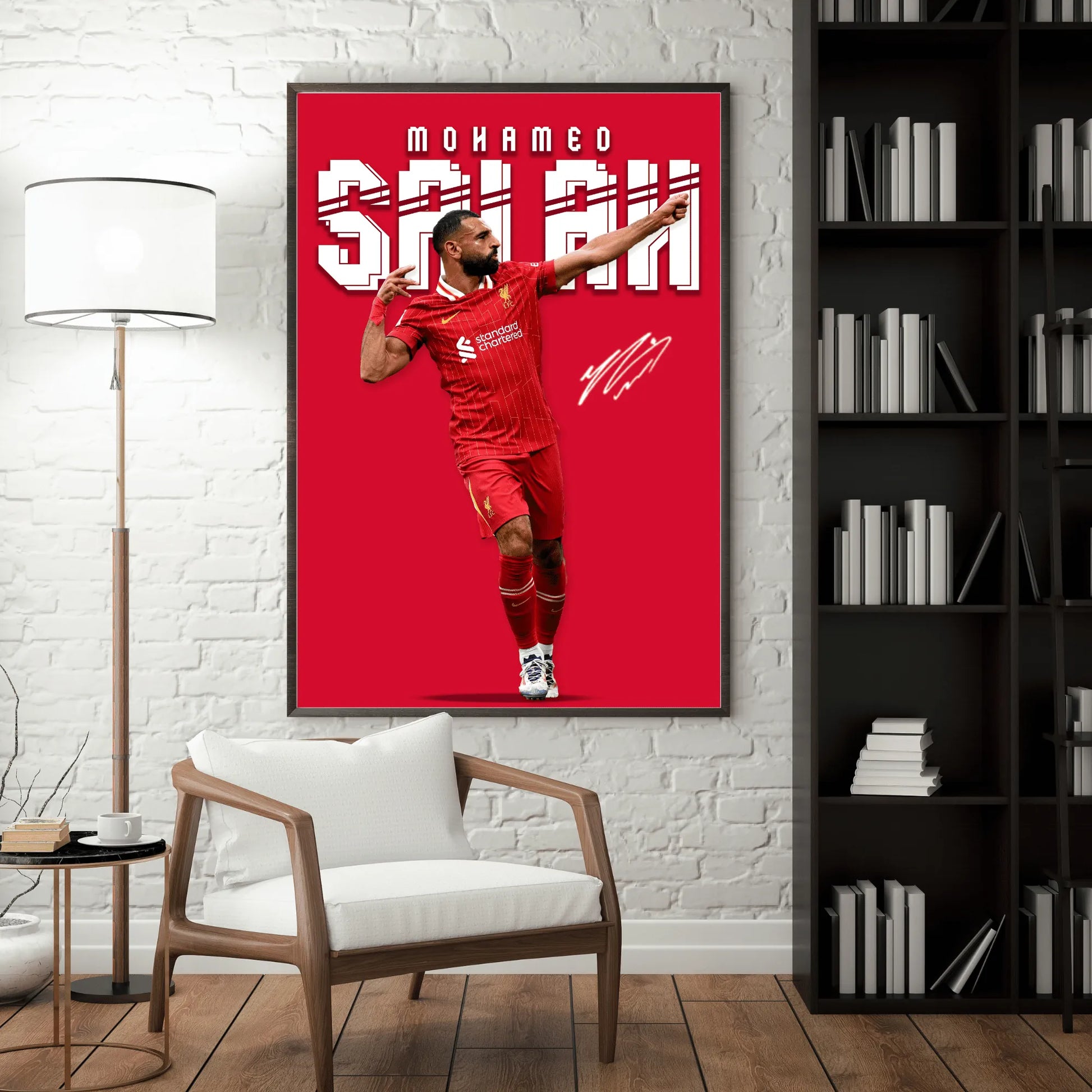 Framed poster of a soccer player in a red uniform on a wall in a room with a chair and bookshelf.