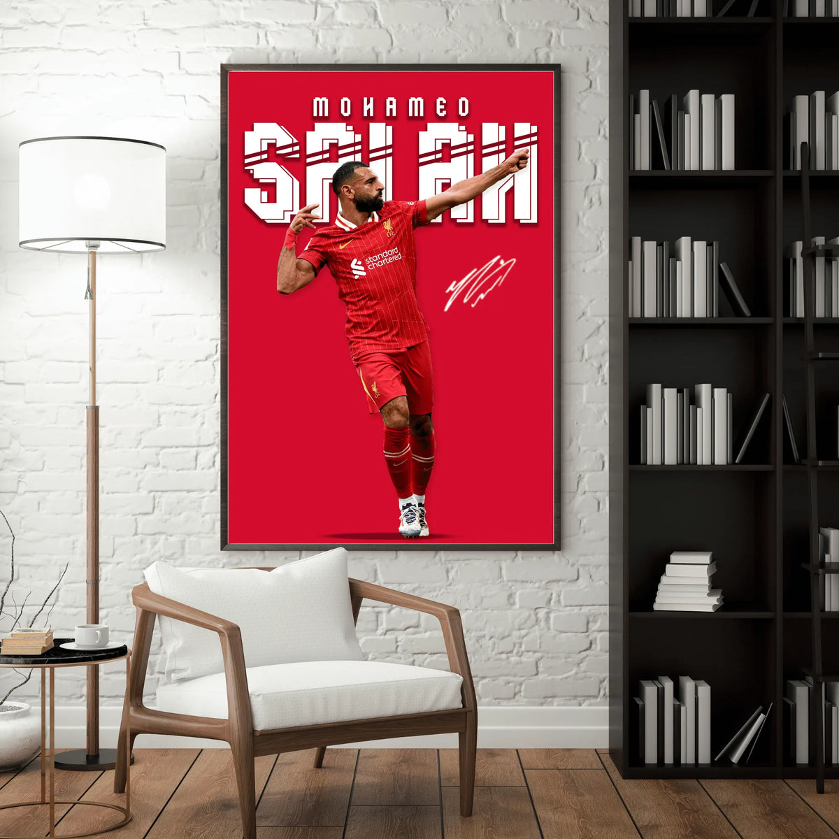 Framed poster of a soccer player in a red uniform on a wall in a room with a chair and bookshelf.